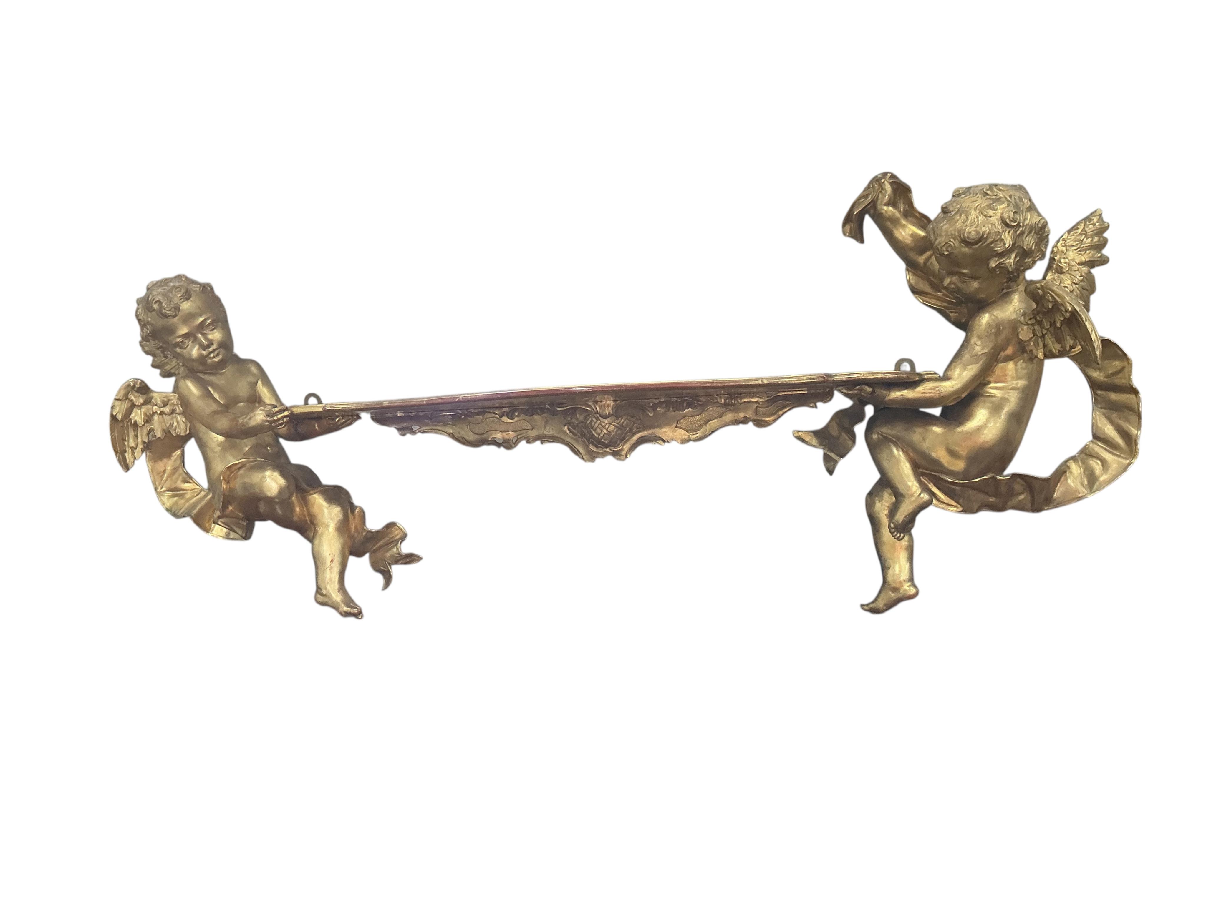 A Victorian style giltwood and composition cherub wall bracket, width 102cm, height 38cm